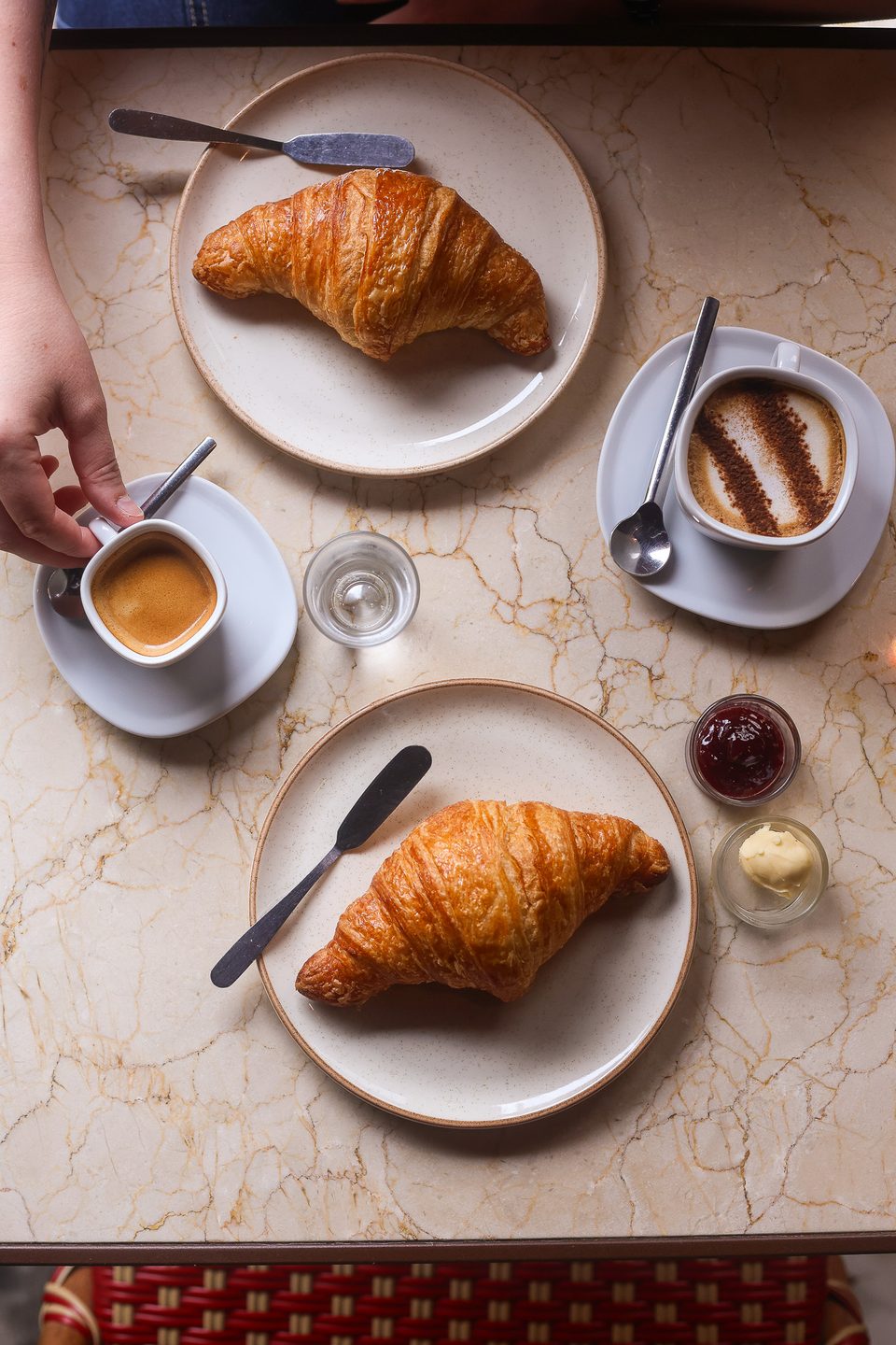 Mesa com croissants, espresso e geleia